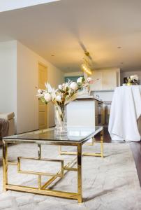 a glass coffee table with a vase of flowers on it at Best location - Luxury and charming loft in Panama City