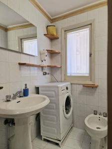 uma casa de banho com uma máquina de lavar roupa e um lavatório em CIVICO 26 em Bisceglie