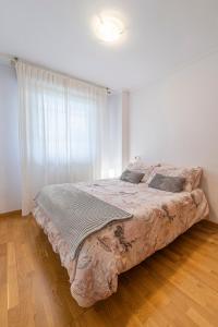 1 dormitorio con 1 cama grande frente a una ventana en APARTAMENTO CARMELA en Santiago de Compostela