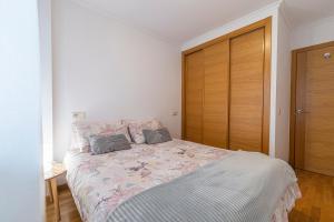 1 dormitorio con 1 cama y puerta de madera en APARTAMENTO CARMELA en Santiago de Compostela