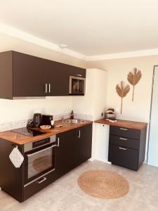 Una cocina con gabinetes negros y un fregadero. en Casa Bukit Gites, en Pierrerue