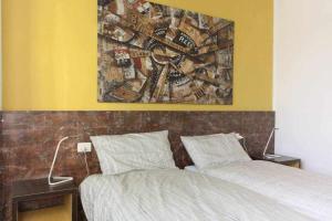 a bedroom with a bed and a painting on the wall at Ospitaci Appartamenti Viale Mezzetti in Foligno