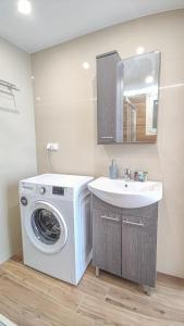 a bathroom with a washing machine and a sink at Fully renovated Studio in Platanias in Plataniás