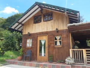 ein kleines Holzhaus mit einer Tür und Fenstern in der Unterkunft Cabañas Limón y Manzana en Finca Maracuba in Jardin