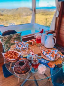une table en verre avec de la nourriture en haut dans l'établissement Cabanas Românticas em meio a Natureza - Anitápolis/SC - CB05, à Annitapolis
