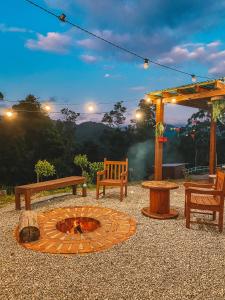 - un foyer extérieur avec des bancs et un kiosque dans l'établissement Cabanas Românticas em meio a Natureza - Anitápolis/SC - CB05, à Annitapolis