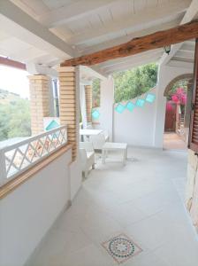 a patio with a balcony with a table and chairs at Sardinia Yellow House in Solanas