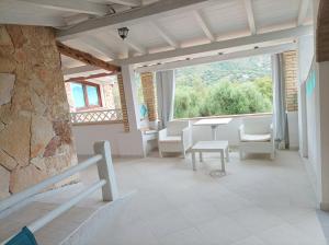 Habitación con mesa, sillas y ventana grande. en Sardinia Yellow House, en Solanas