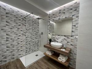 een badkamer met een wastafel en een douche met een spiegel bij SUNSEA - Enjoy Your Family in Capo Vaticano