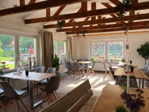 a dining room with tables and chairs and windows at Pension Sternschnuppe, Treseburg Harz, unmittelbar am Wasser in Thale