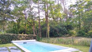 a swimming pool in a yard with trees at Maison Solyselva Piscine- Proche océan- Climatisée in Saubion
