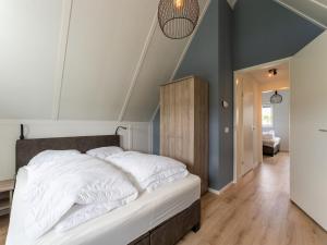 1 dormitorio con 1 cama grande con sábanas blancas en Pleasant holiday home in Scherpenisse with garden en Scherpenisse