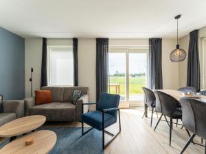 sala de estar con sofá, mesa y sillas en Pleasant holiday home in Scherpenisse with garden, en Scherpenisse
