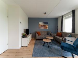 sala de estar con sofá y mesa en Pleasant holiday home in Scherpenisse with garden, en Scherpenisse