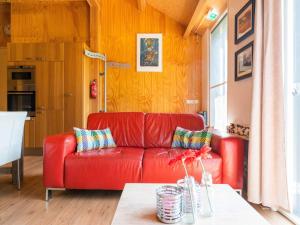 BeilenにあるA lovely cottage on the Dwingelderveld nature parkのリビングルーム(赤いソファ、テーブル付)