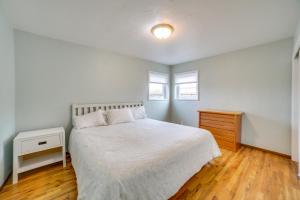 a bedroom with a white bed and a wooden floor at Seaside Vacation Rental with Patio Near Monterey Bay in Seaside