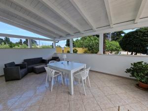 een witte tafel en stoelen op een patio bij Meraviglia d'Otranto in Otranto