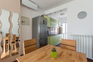 a kitchen and dining room with a wooden table and chairs at Olive Hill Apartment in Portorož