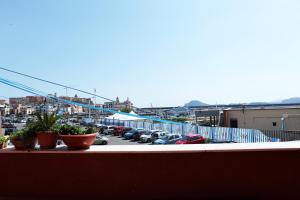 a balcony with potted plants and a parking lot at Albatros Suite Home in Pozzuoli