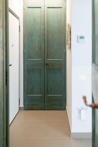 a green door in a hallway with a tile floor at SeSil Amare in Porto Recanati