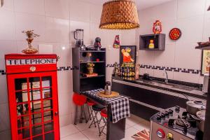 a kitchen with a red telephone booth in a kitchen at Casa Duplex Aconchegante in Campina Grande