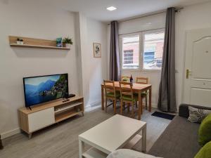 a living room with a television and a table at Apartamentos Bielsa 'Madrid Río' in Madrid