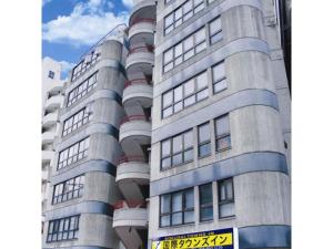 un grand bâtiment avec un panneau devant lui dans l'établissement Kokusai Towns Inn - Vacation STAY 35452v, à Naha