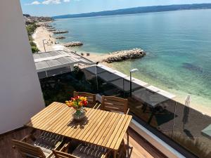 a balcony with a table and chairs and the water at Apartments Goro in Podstrana