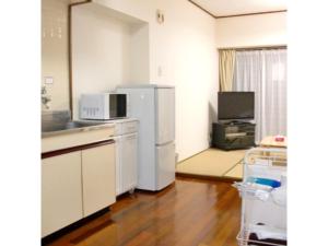 La cuisine est équipée d'un réfrigérateur blanc et d'un évier. dans l'établissement Kokusai Towns Inn - Vacation STAY 35453v, à Naha