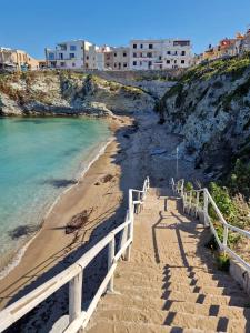 un escalier menant à une plage avec des bâtiments dans l'établissement Casa vacanza Melf, à Terrasini