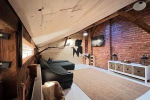 a living room with a couch and a brick wall at The Stable House in Bucharest