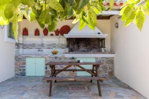 a kitchen with a wooden table in front of a counter at Margini's Country House in Panormos Skopelos