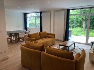 Una sala de estar con dos sofás y una mesa. en Modern House next Disneyland, en Esbly