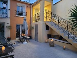 um pátio com uma escada, uma mesa e um guarda-chuva em L Arancio - Centre village - Piscine - 4 pers em Bessan