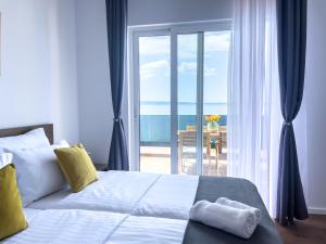 a bedroom with a bed with a view of the ocean at Apartments Goro in Podstrana