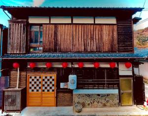 ein asiatisches Gebäude mit roten Dekorationen an der Seite in der Unterkunft Kominka Dining Bar Yumeyashiki- Vacation STAY 50909v in Karatsu