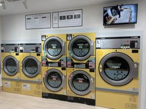 4 lavadoras están alineadas en una habitación en Tennen Onsen Kakenagashi no Yado Hotel Pony Onsen - Vacation STAY 50911v en Towada