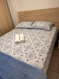 a bed with two pairs of shoes on it at Apartamento West Flat in Mossoró