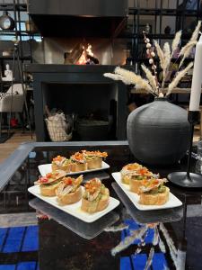 3 platos de comida en una mesa con chimenea en Hotel Koferita en Melissourgoí
