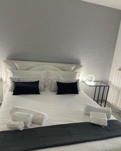duże białe łóżko z czarno-białymi poduszkami w obiekcie Maison 115 w mieście Cassano delle Murge +18 zdjęć