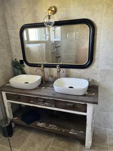 een badkamer met 2 wastafels en een grote spiegel bij Gîte le Terrier in Hotot-en-Auge