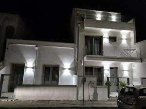 una casa blanca con un coche aparcado delante de ella en Mare D'amare, en Porto Cesareo
