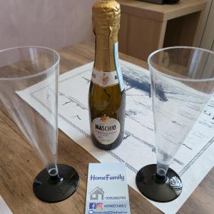 eine Flasche Champagner auf einem Tisch mit zwei Gläsern in der Unterkunft HomeFamily in Lido di Ostia