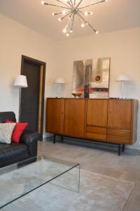 a living room with a couch and a chandelier at Appartement-terrasse parking privé Meublé de Tourisme 4 étoiles in Belfort