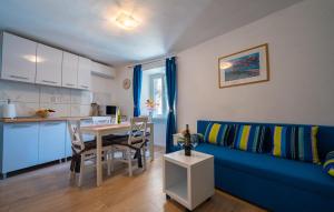 a living room with a blue couch and a table at Apartment Rose in Korčula +11 photos