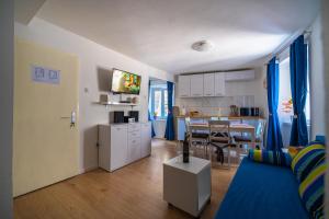 a living room with a blue couch and a kitchen at Apartment Rose in Korčula