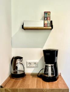 eine Kaffeemaschine auf einem Holzregal neben einer Kaffeekanne in der Unterkunft Sali - R1 - Apartmenthaus, WLAN, TV in Remscheid
