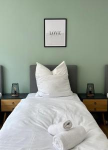 ein weißes Bett mit zwei Handtüchern darüber in der Unterkunft Sali - R1 - Apartmenthaus, WLAN, TV in Remscheid