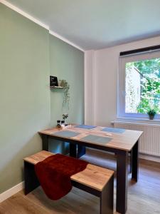 Zimmer mit einem Tisch, einer Bank und einem Fenster in der Unterkunft Sali - R1 - Apartmenthaus, WLAN, TV in Remscheid