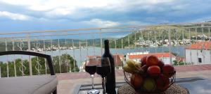una mesa con un bol de fruta y una botella de vino en Apartments Toni, en Rogoznica